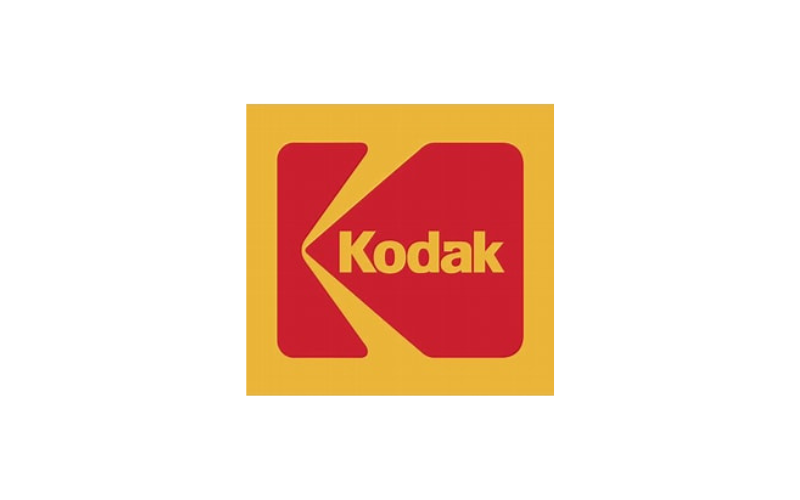 A vintage Kodak logo with a red and yellow design, featuring the word 'Kodak' inside a stylized film reel icon.